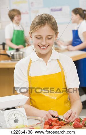 Female student slicing berries in cooking class View Large Photo Image Stock Photo - Female student slicing berries in cooking class. Fotosearch
