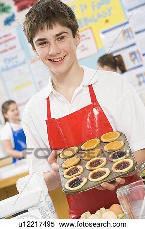 Male student holding a tray of tarts in cooking class View Large Photo Image Stock Photography - Male student holding a tray of tarts in cooking class. Fotosearch