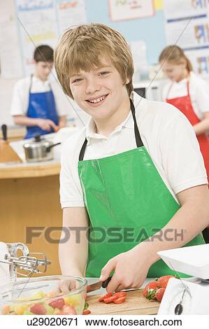 Male student slicing berries in cooking class View Large Photo Image Stock Image - Male student slicing berries in cooking class. Fotosearch
