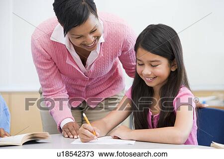 Student in class writing with teacher View Large Photo Image Stock Image - Student in class writing with teacher. Fotosearch
