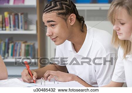 Stock Image - Student writing and studying. Fotosearch