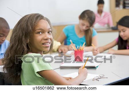 Students in class writing with teacher in background (selective focus) View Large Photo Image Stock Image - Students in class writing with teacher in background (selective focus). Fotosearch