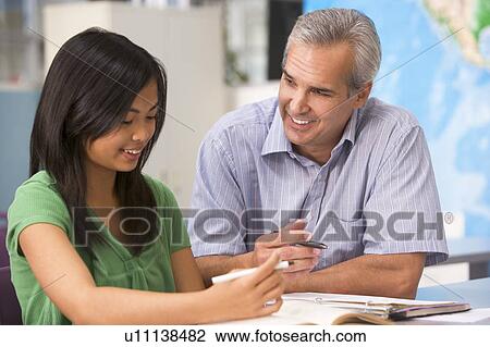 Teacher giving personal instruction to female student View Large Photo Image Stock Image - Teacher giving personal instruction to female student. Fotosearch