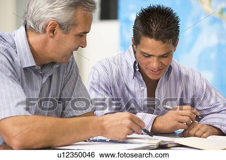 Teacher giving personal instruction to male student View Large Photo Image Stock Photograph - Teacher giving personal instruction to male student. Fotosearch