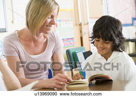 Student in class reading book with teacher View Large Photo Image Stock Image - Student in class reading book with teacher. Fotosearch