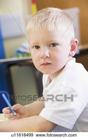 Stock Photo - Student in class writing in notebook (selective focus). Fotosearch