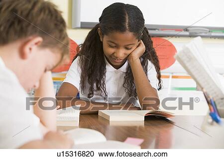 Stock Image - Students in class reading books (selective focus). Fotosearch