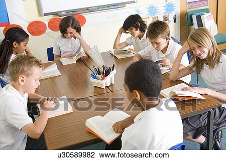 Stock Image - Students in class reading books. Fotosearch