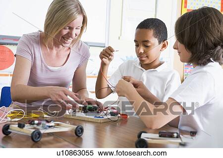 Stock Photography - Students in class with teacher making electronic cars. Fotosearch