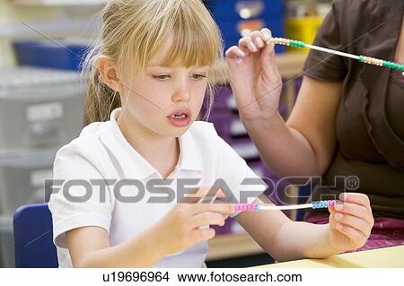 Picture - Students in math class using counting beads (selective focus). Fotosearch