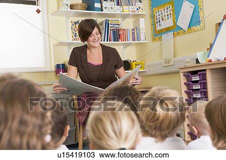 Teacher in class reading with students in foreground (selective focus) View Large Photo Image Stock Image - Teacher in class reading with students in foreground (selective focus). Fotosearch