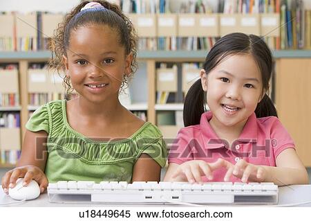 Stock Photography - Two students in class at computer keyboard. Fotosearch