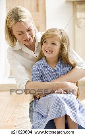 Picture - Woman in front hallway hugging young girl and smiling. Fotosearch