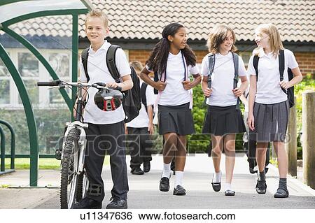 Stock Photograph - Students leaving school one with a bicycle. Fotosearch