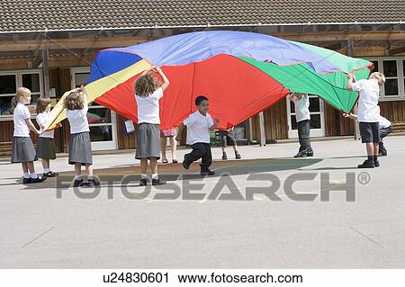 Students outdoors during recess playing with a parachute View Large Photo Image Stock Image - Students outdoors during recess playing with a parachute. Fotosearch