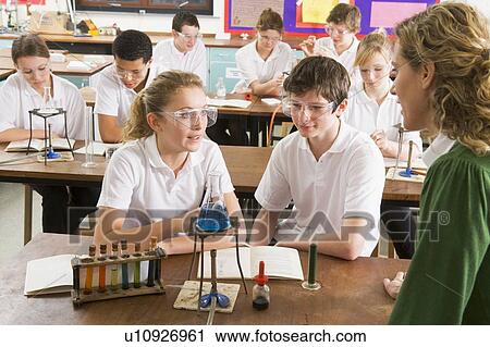 Stock Image - Students performing science experiments in classroom. Fotosearch