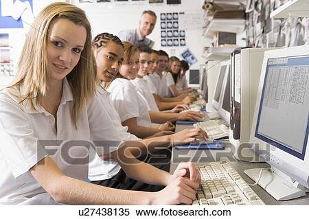 Students working on computer workstations with teacher View Large Photo Image Stock Photography - Students working on computer workstations with teacher. Fotosearch