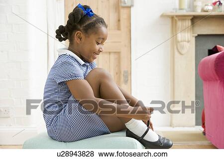 Young girl in front hallway fixing shoe and smiling View Large Photo Image Stock Photo - Young girl in front hallway fixing shoe and smiling. Fotosearch