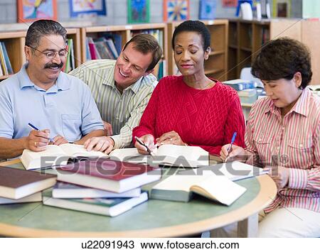 Four people in library with books and notepads (selective focus) View Large Photo Image Stock Image - Four people in library with books and notepads (selective focus). Fotosearch
