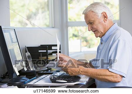 Man in home office with paperwork and computer View Large Photo Image Stock Photo - Man in home office with paperwork and computer. Fotosearch
