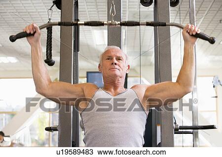 Stock Image - Man Weight Training At Gym. Fotosearch