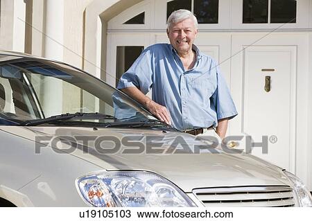 Senior man standing with his car outside his home View Large Photo Image Stock Image - Senior man standing with his car outside his home. Fotosearch