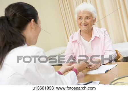 Woman in doctor's office smiling View Large Photo Image Stock Image - Woman in doctor's office smiling. Fotosearch