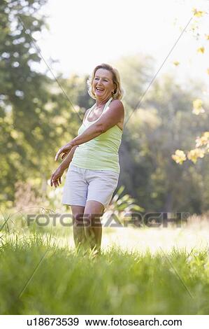 Stock Photo - Woman walking outdoors smiling. Fotosearch