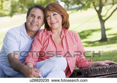 Couple at a picnic holding hands and smiling View Large Photo Image Stock Photography - Couple at a picnic holding hands and smiling. Fotosearch