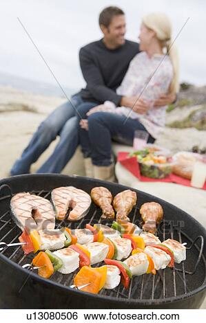 Stock Photograph - Couple Cooking On A Barbeque. Fotosearch