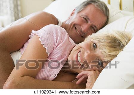 Couple lying in bed smiling View Large Photo Image Stock Image - Couple lying in bed smiling. Fotosearch