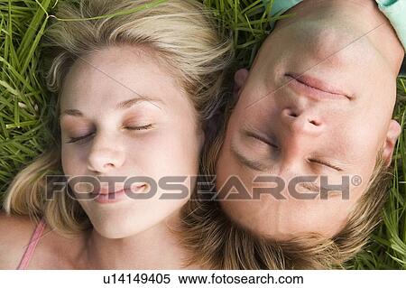 Couple lying in grass sleeping View Large Photo Image Stock Photography - Couple lying in grass sleeping. Fotosearch