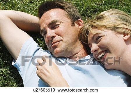 Stock Photo - Couple lying outdoors smiling. Fotosearch