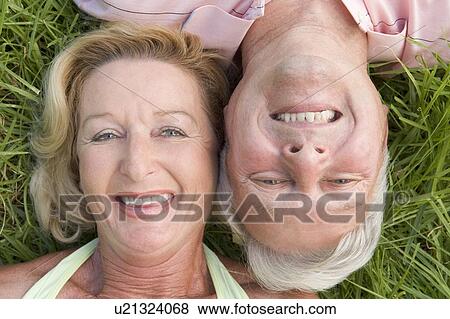 Couple relaxing outdoors and smiling View Large Photo Image Stock Photo - Couple relaxing outdoors and smiling. Fotosearch