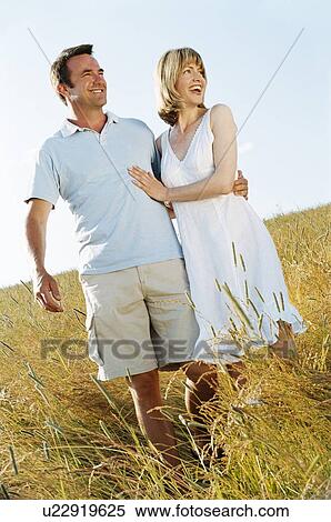 Stock Photography - Couple standing outdoors smiling. Fotosearch