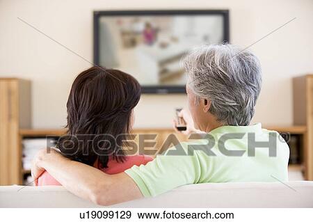Couple watching television using remote control View Large Photo Image Stock Photo - Couple watching television using remote control. Fotosearch
