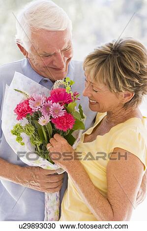 Husband giving wife flowers and smiling View Large Photo Image Stock Image - Husband giving wife flowers and smiling. Fotosearch