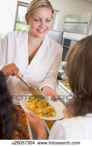 Picture - Lunch lady serving rice to student. Fotosearch