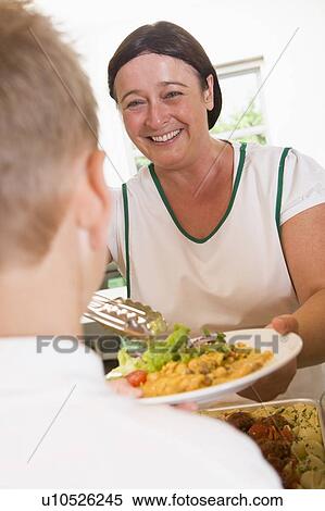 Lunch lady serving salad to student View Large Photo Image Stock Photography - Lunch lady serving salad to student. Fotosearch