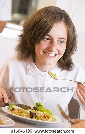 Student in cafeteria eating lunch (selective focus) View Large Photo Image Stock Photograph - Student in cafeteria eating lunch (selective focus). Fotosearch