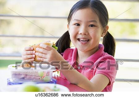 Student outdoors eating lunch (selective focus) View Large Photo Image Stock Photograph - Student outdoors eating lunch (selective focus). Fotosearch