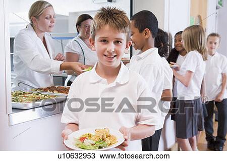 Stock Image - Students in cafeteria line with one holding his healthy meal and looking at camera (depth of field). Fotosearch