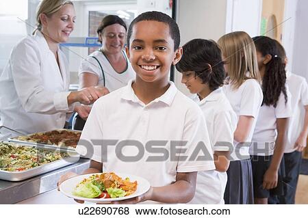 Students in cafeteria line with one holding his healthy meal and looking at camera (depth of field) View Large Photo Image Stock Photo - Students in cafeteria line with one holding his healthy meal and looking at camera (depth of field). Fotosearch