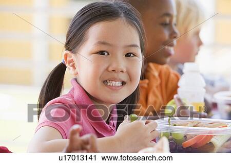 Stock Image - Students outdoors eating lunch (selective focus). Fotosearch