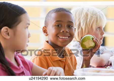 Stock Image - Students outdoors eating lunch (selective focus). Fotosearch