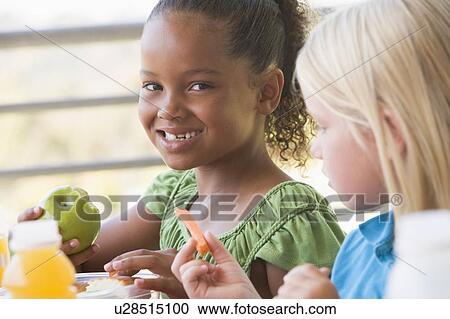 Stock Image - Students outdoors eating lunch (selective focus). Fotosearch