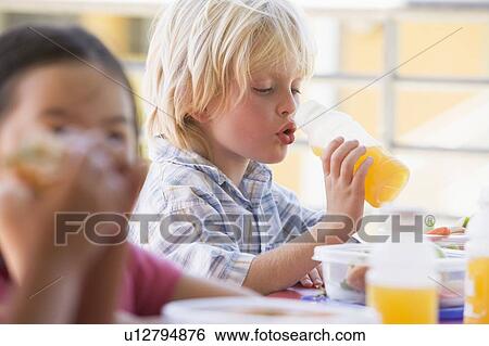 Stock Photograph - Students outdoors eating lunch (selective focus). Fotosearch