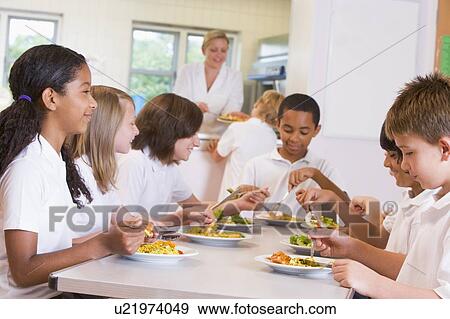 Students sitting at cafeteria table eating lunch (depth of field) View Large Photo Image Stock Photo - Students sitting at cafeteria table eating lunch (depth of field). Fotosearch