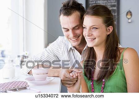 Stock Image - Young couple having tea in a cafeteria. Fotosearch