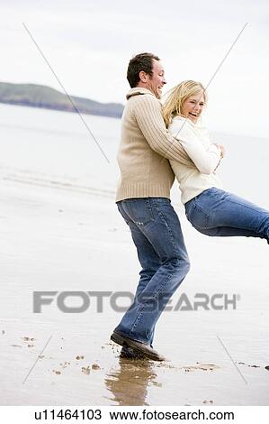 Couple playing on beach smiling View Large Photo Image Stock Image - Couple playing on beach smiling. Fotosearch